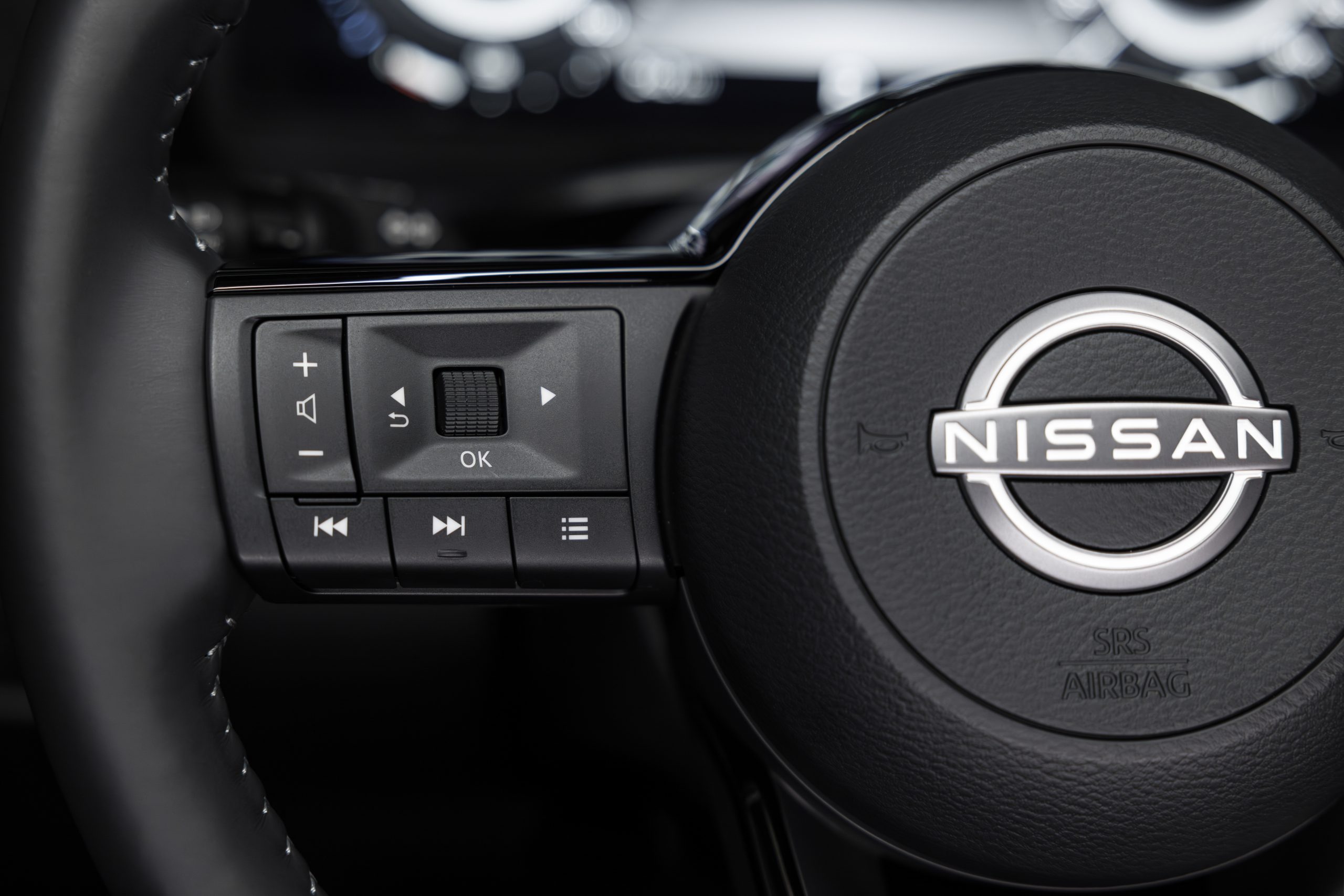 Close up of a steering wheel

Description automatically generated